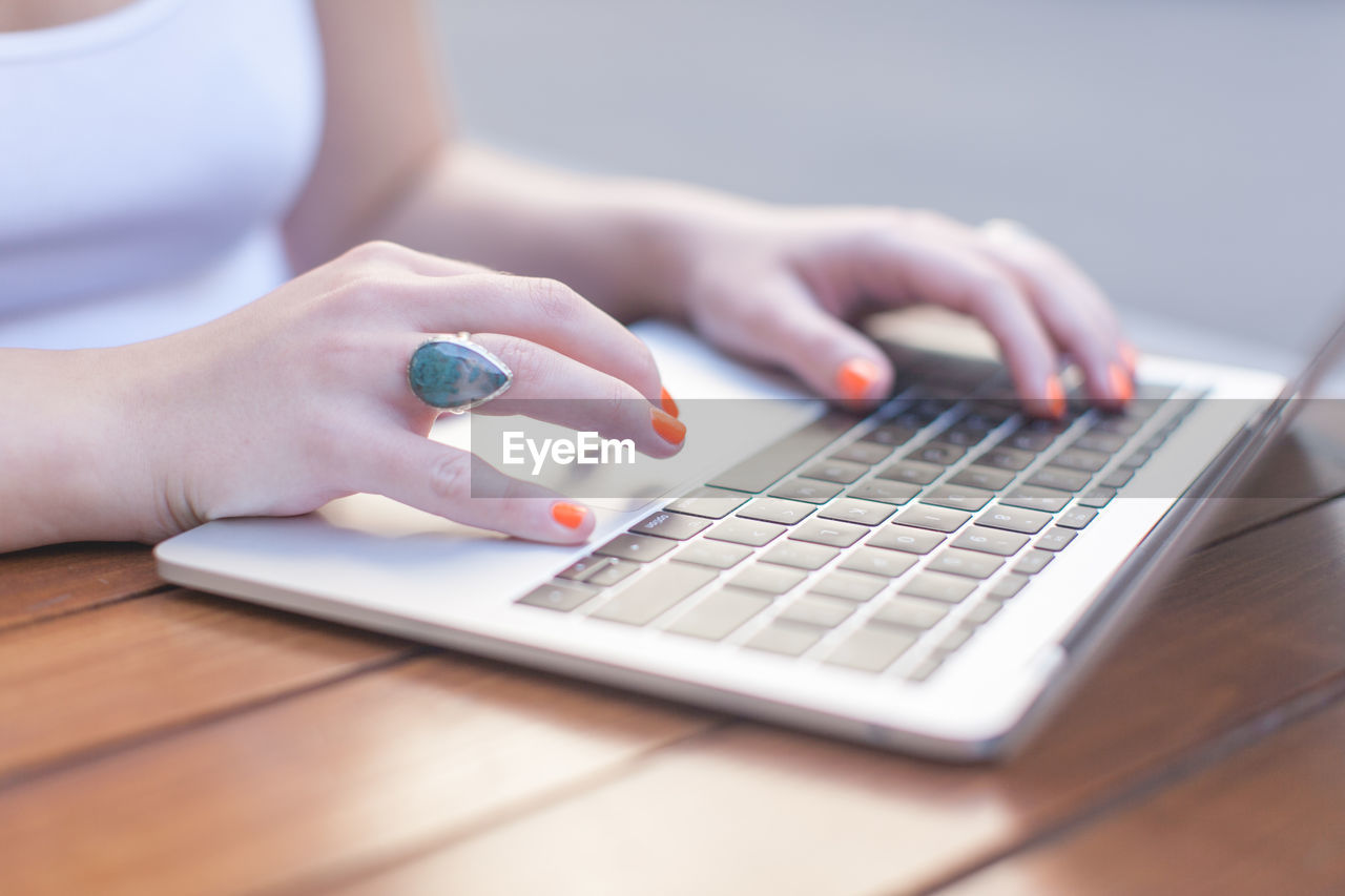 Midsection of woman using laptop