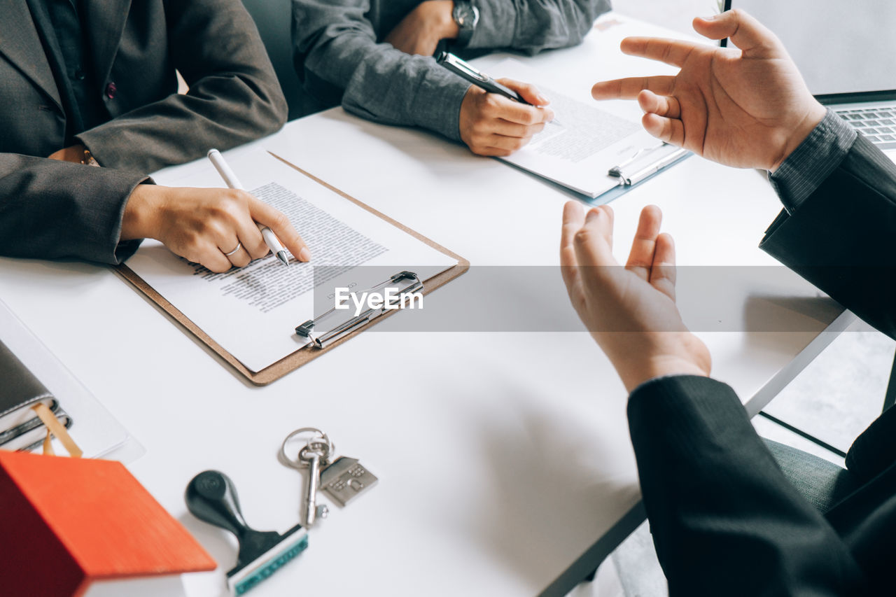 Cropped hands of lawyer gesturing while sitting at desk