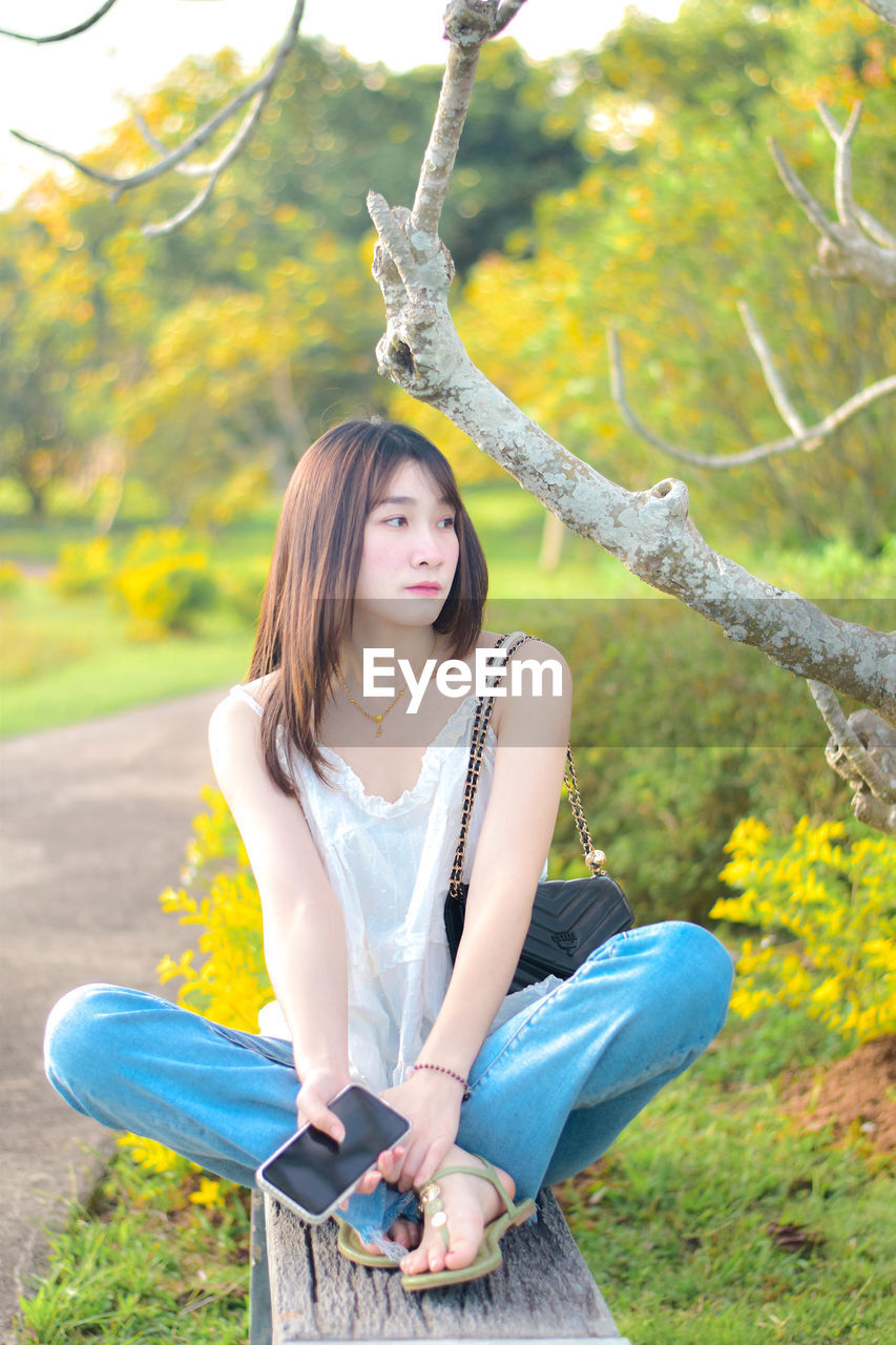 Portrait of young woman sitting on field