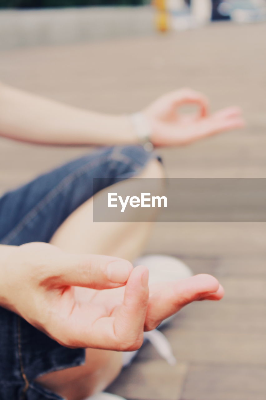 Low section of person doing yoga on parquet floor