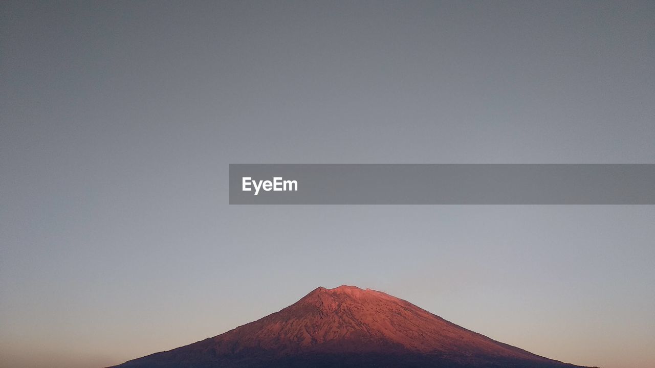 Low angle view of volcanic mountain against clear sky