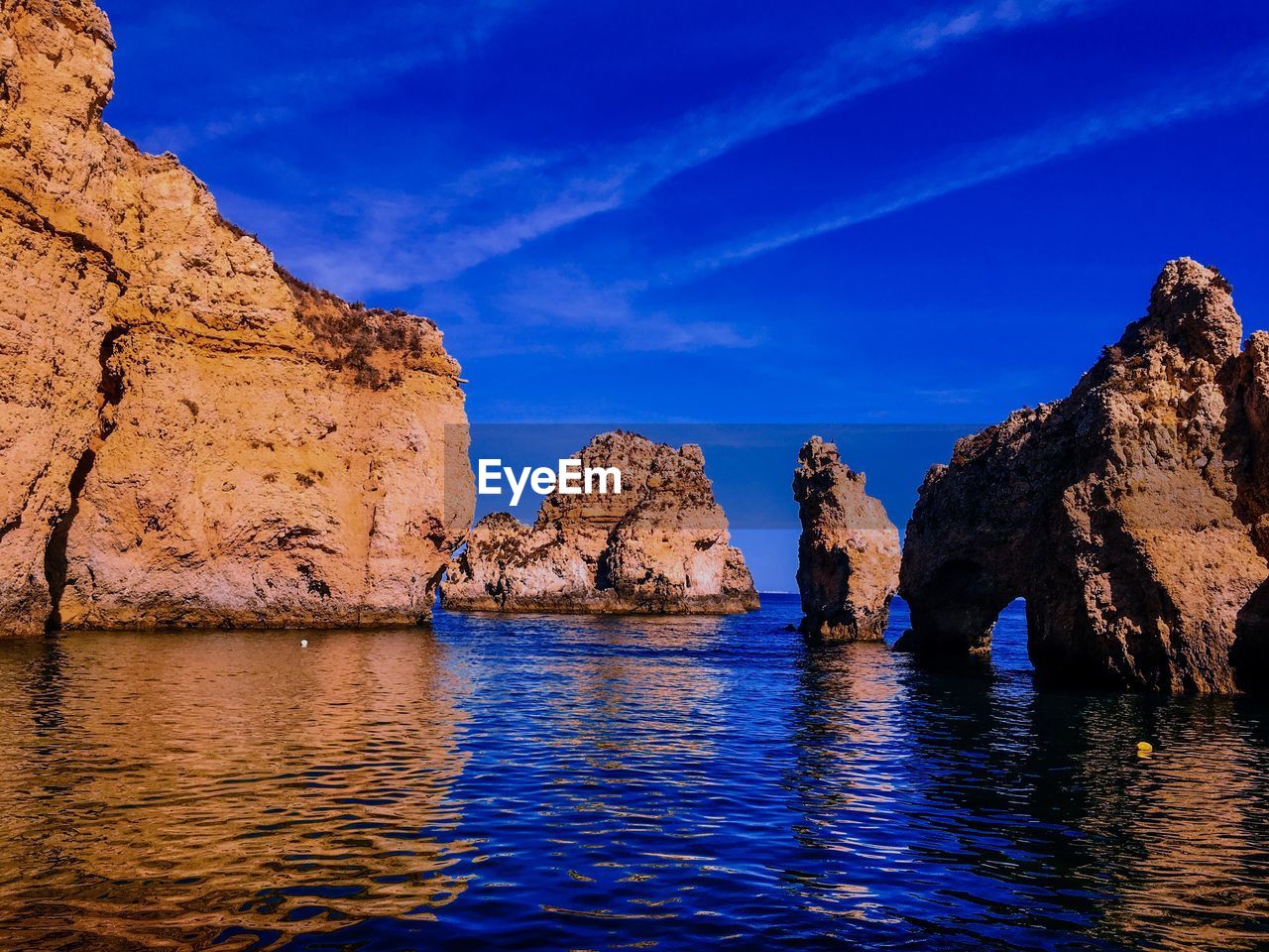 PANORAMIC VIEW OF ROCKS IN SEA AGAINST BLUE SKY