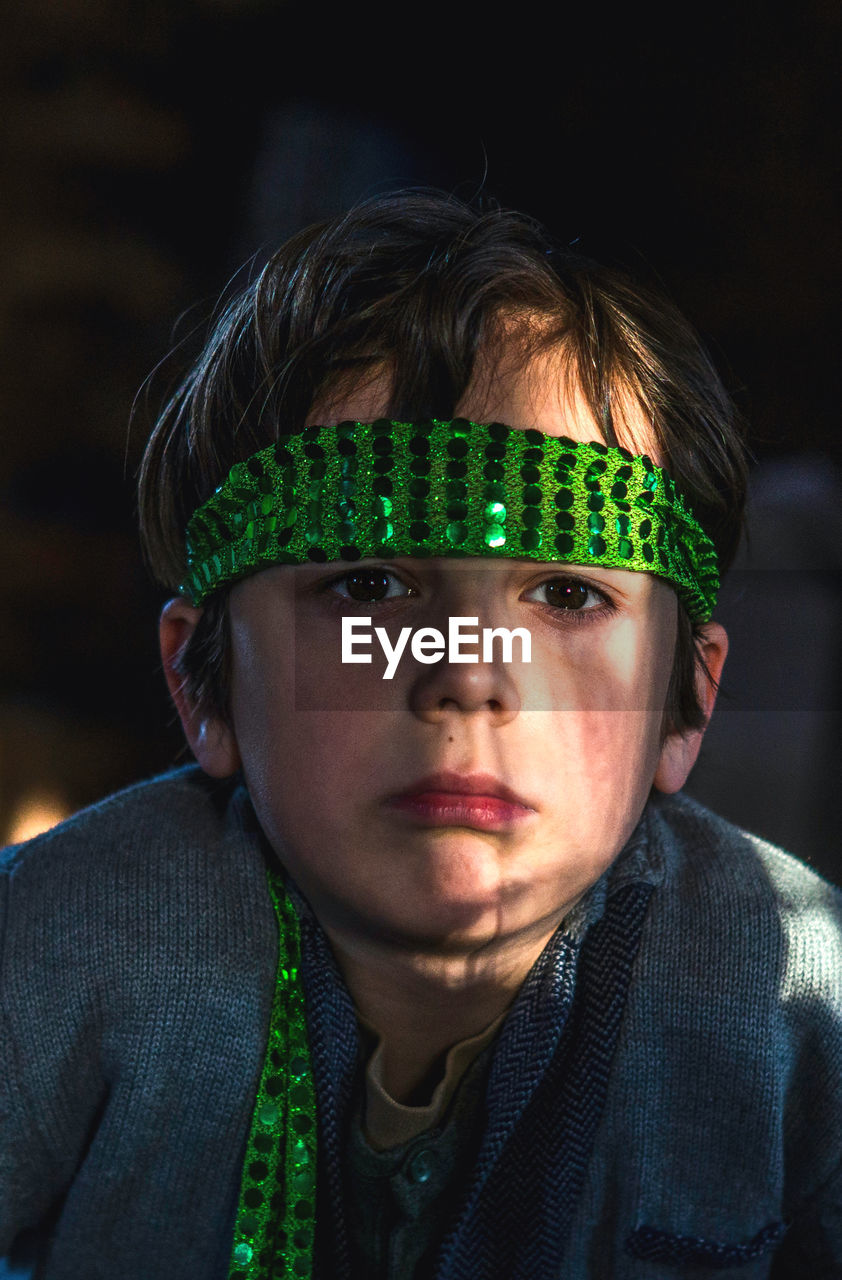 Close-up portrait of boy wearing green head band