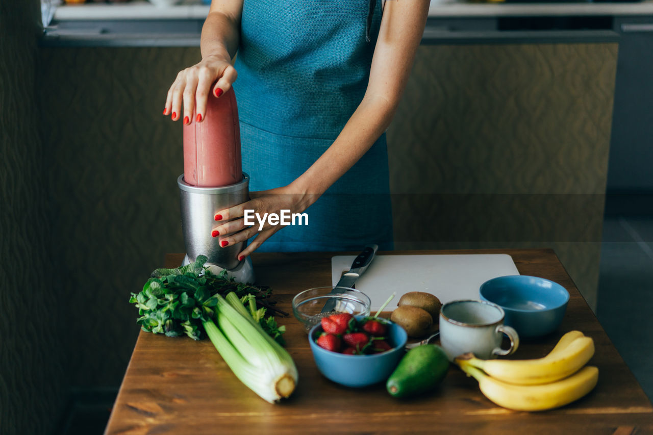 Midsection of woman preparing food in kitchen