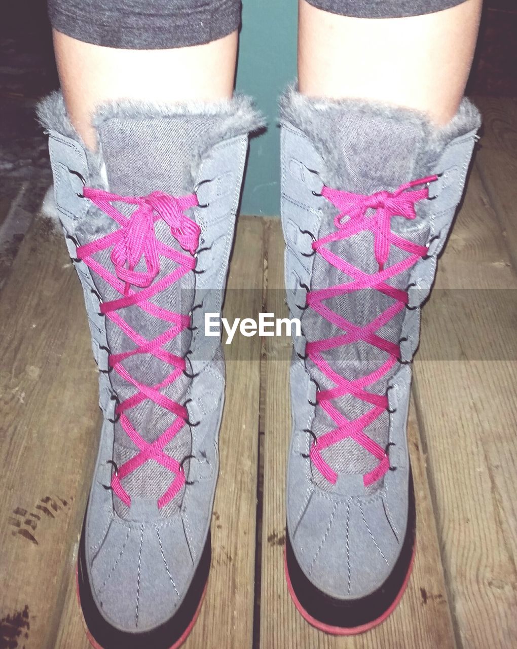 Low section of woman wearing boots on floorboard