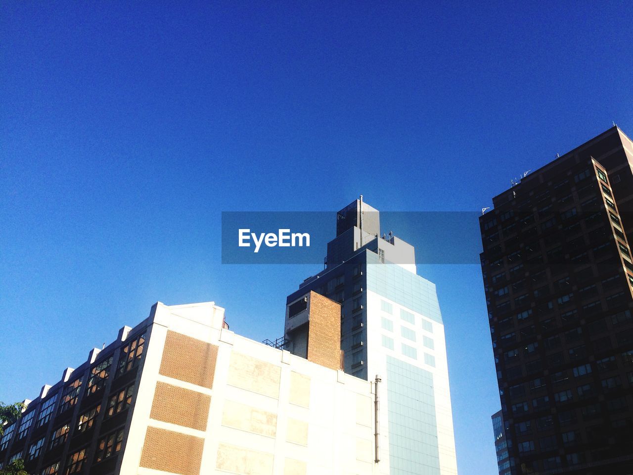 Low angle view of buildings against clear blue sky