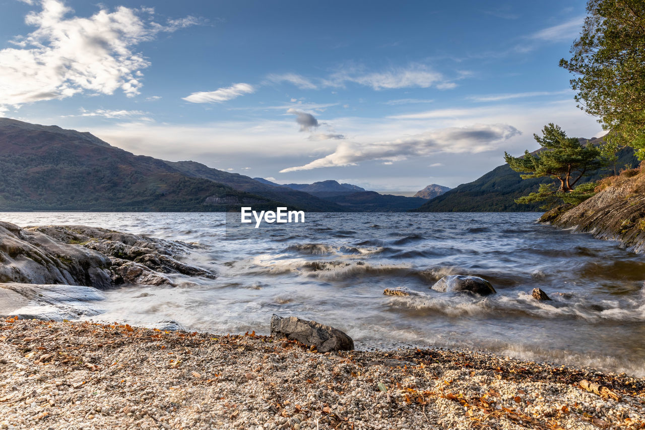 SCENIC VIEW OF SEA BY MOUNTAINS AGAINST SKY