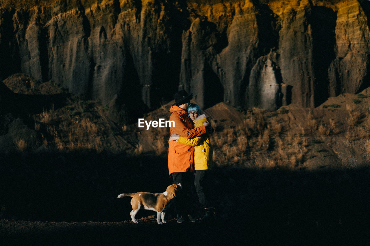 Dog walking on rock and a coule in love