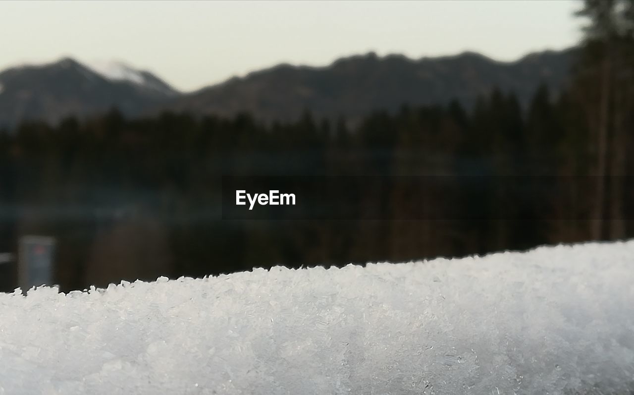 FROZEN LAKE AGAINST MOUNTAINS