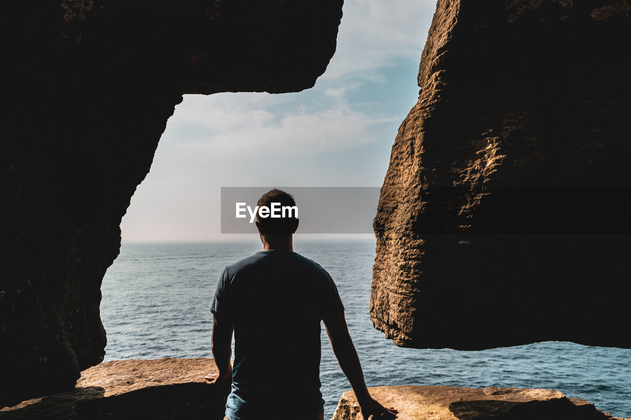 Rear view of man looking at sea