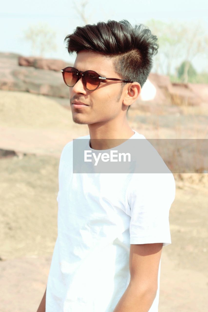 Young man wearing sunglasses standing outdoors
