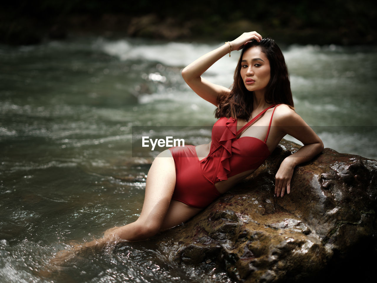 Portraiture shot of a beautiful asian female model in bikini at a river