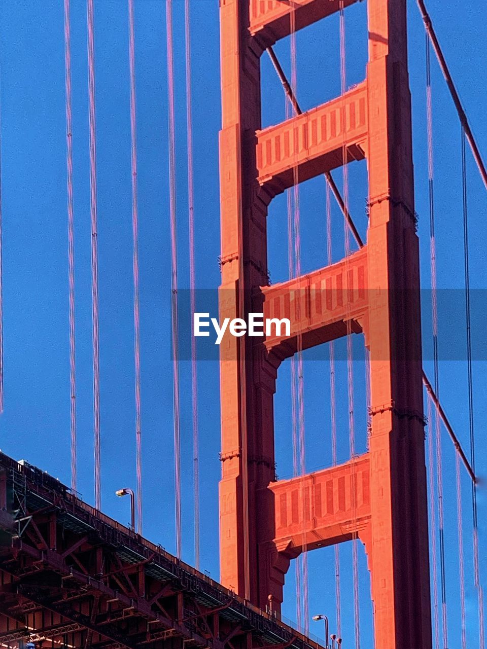 architecture, built structure, blue, sky, no people, low angle view, facade, building exterior, transportation, nature, suspension bridge, bridge, landmark, metal, industry, city, clear sky, day, outdoors, red, line, travel destinations, skyscraper