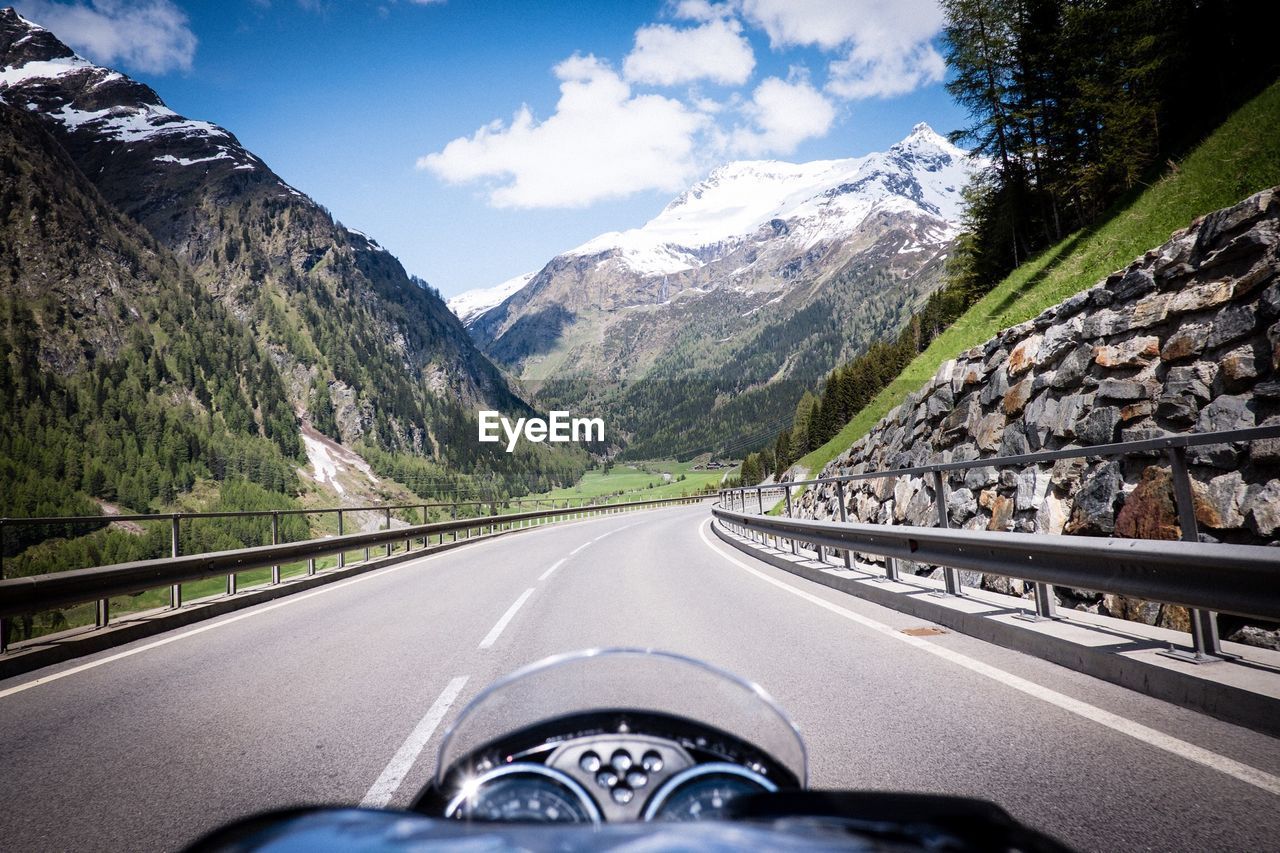 Motorcycle on road amidst mountains against sky