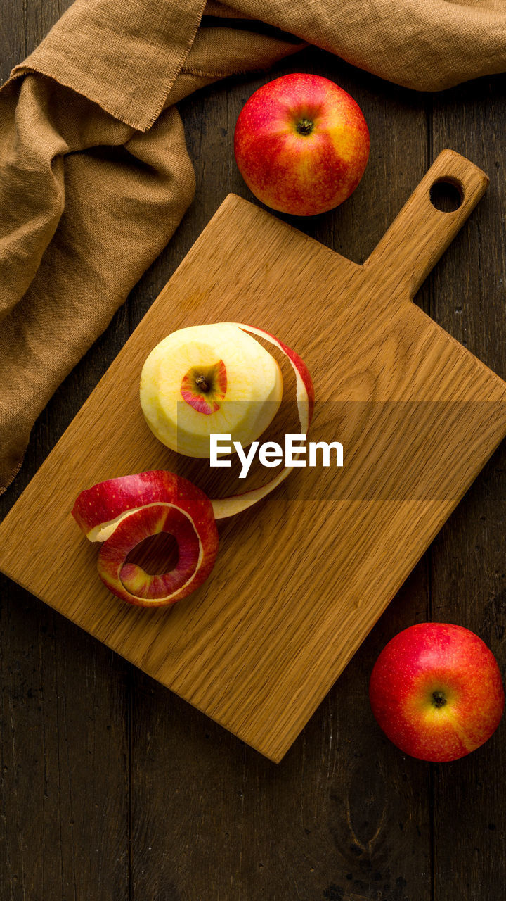 Peeled red apples on wooden cutting board. food background vertical