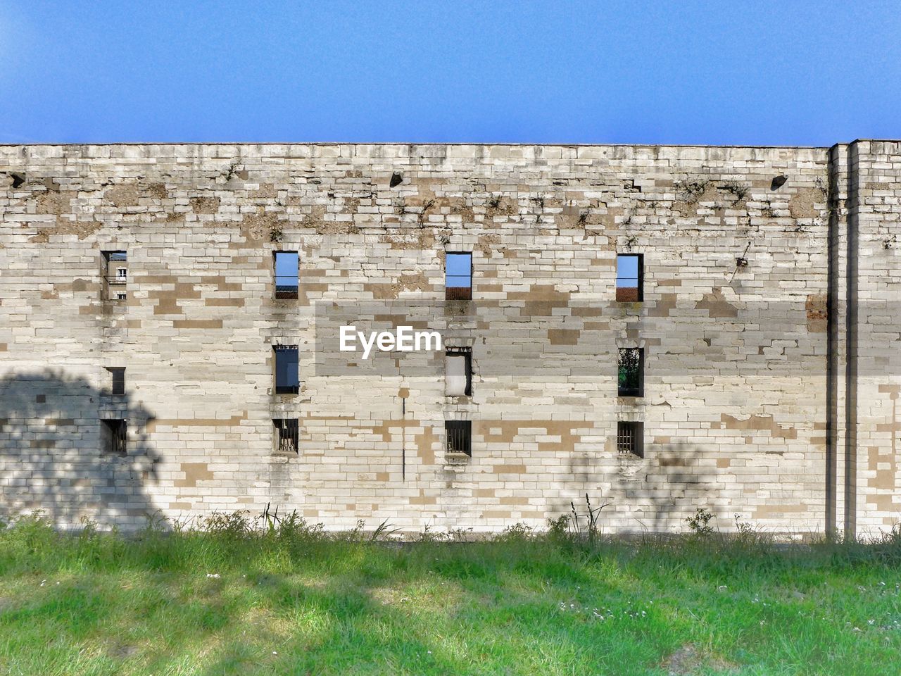 OLD BUILDING ON FIELD AGAINST CLEAR SKY