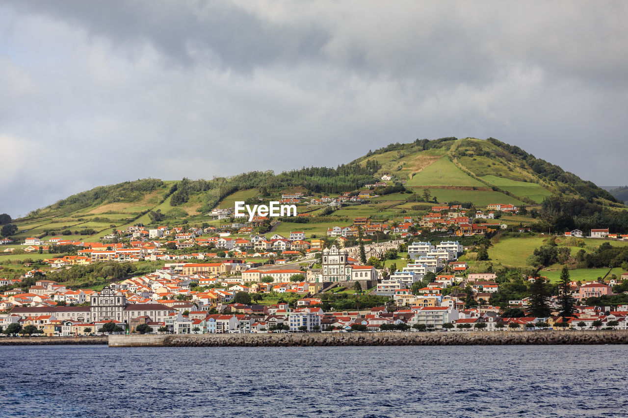 Townscape by sea against sky