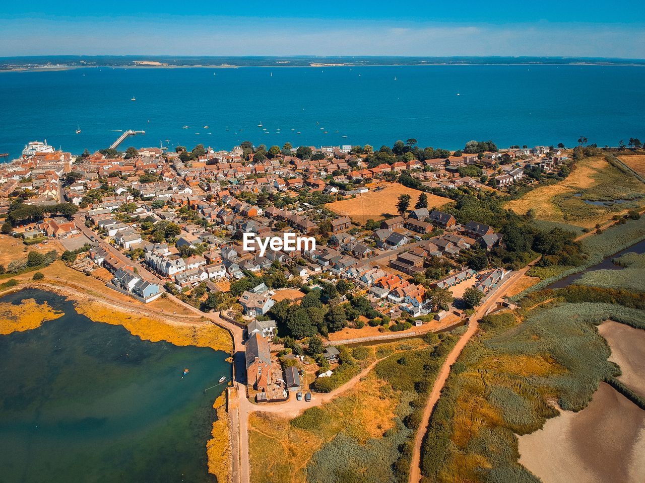 HIGH ANGLE VIEW OF TOWNSCAPE BY SEA AGAINST BUILDINGS