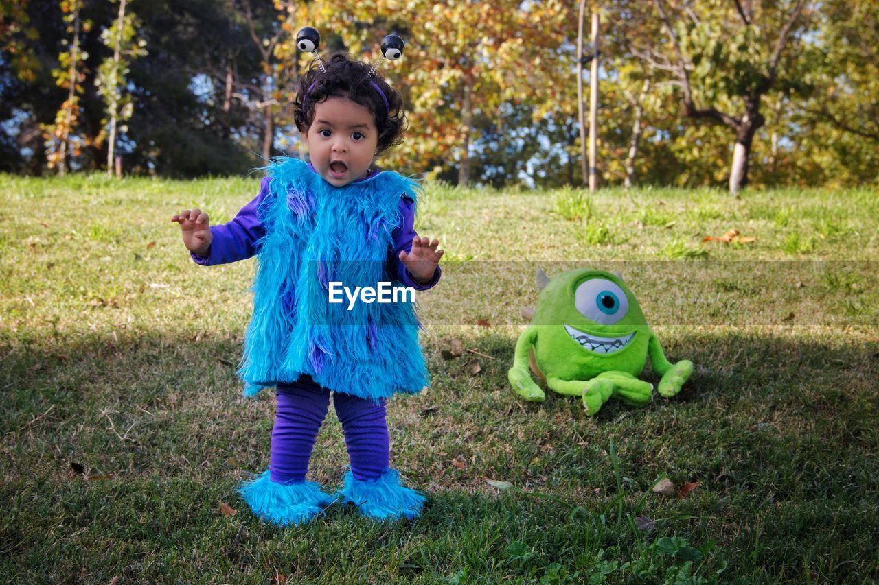 GIRL PLAYING WITH TOY IN GRASS