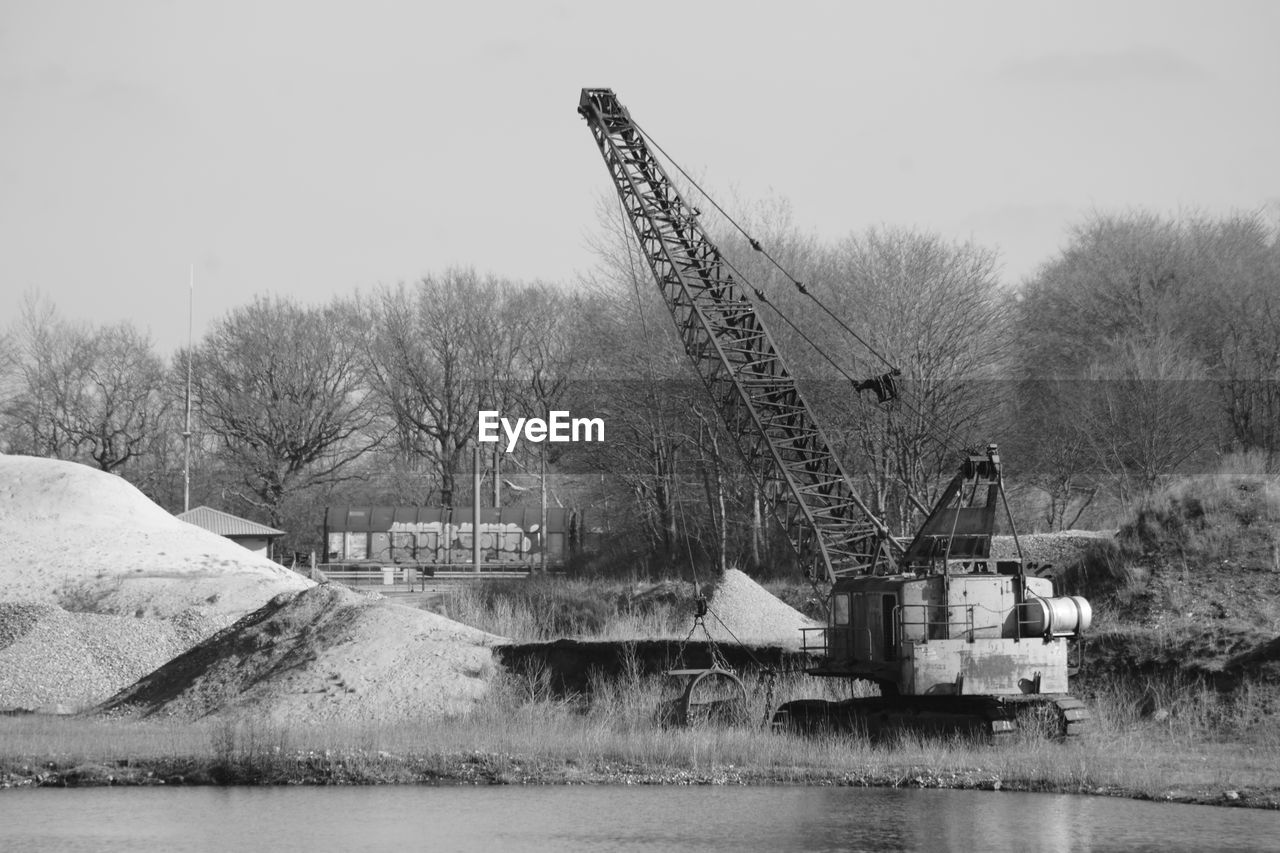 water, machinery, transport, nature, industry, black and white, no people, tree, vehicle, sky, architecture, day, dredging, waterway, snow, monochrome photography, built structure, bridge, crane - construction machinery, monochrome, plant, construction industry, construction site, transportation, outdoors, winter, environment, construction machinery