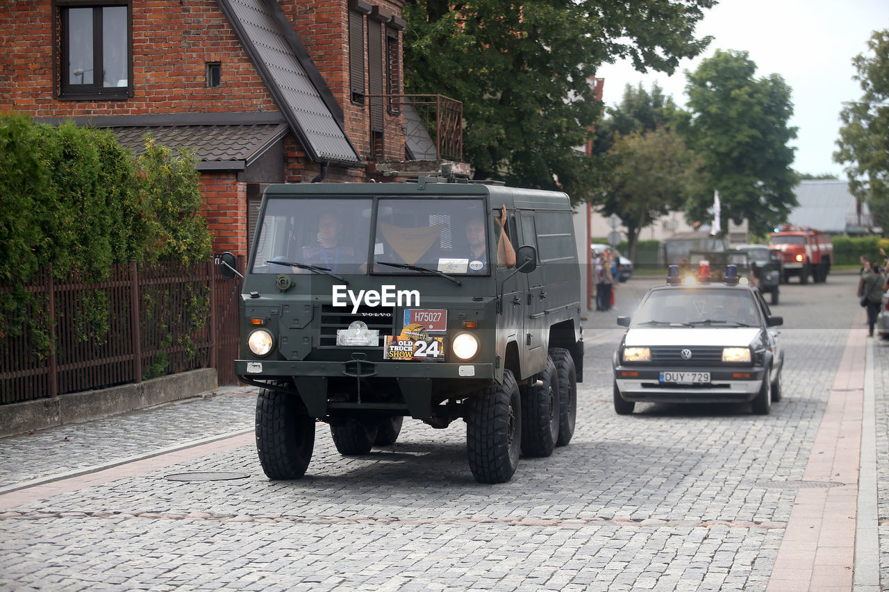 VEHICLES ON ROAD ALONG BUILDINGS