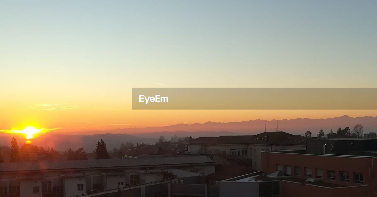 VIEW OF CITYSCAPE AGAINST CLEAR SKY DURING SUNSET