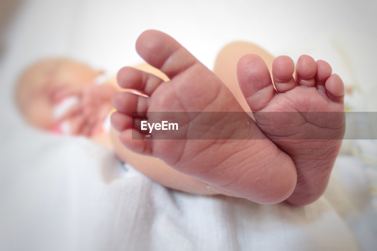 Low section of baby girl lying down on bed