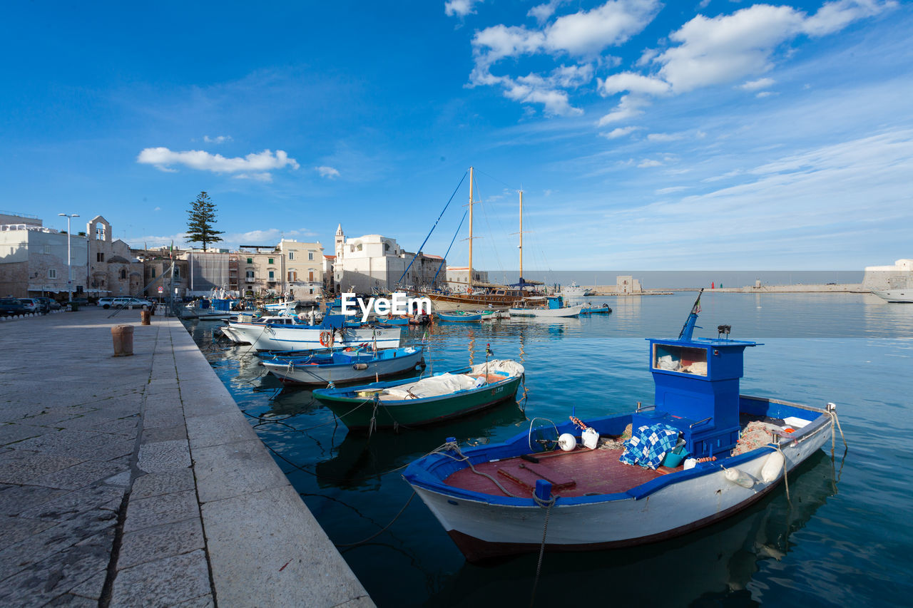 SAILBOATS MOORED IN HARBOR