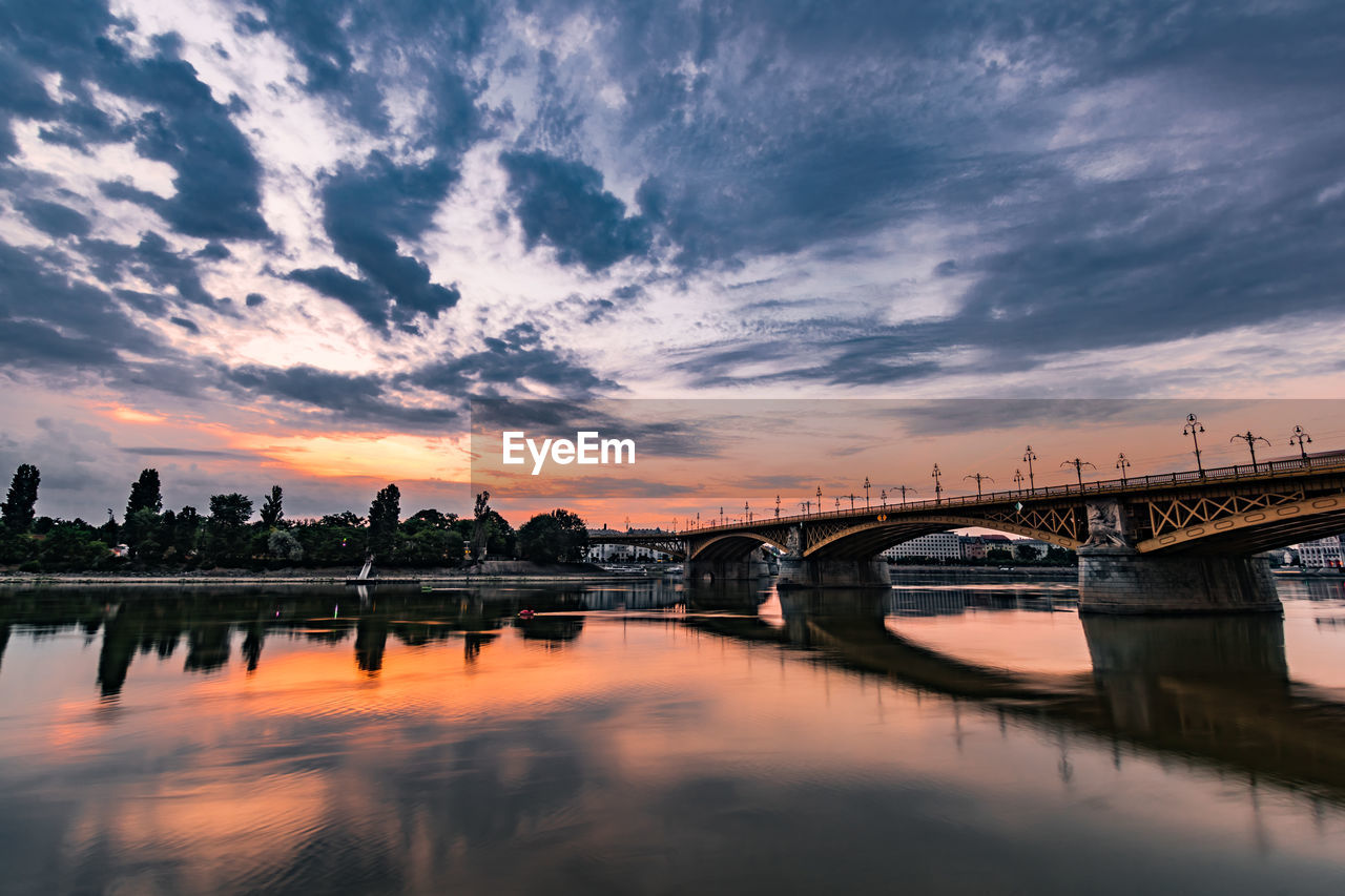 Bridge over river against sky during sunset