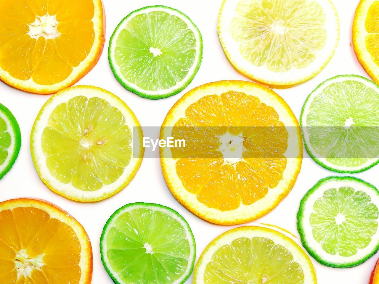 Full frame shot of oranges and limes slices over white background