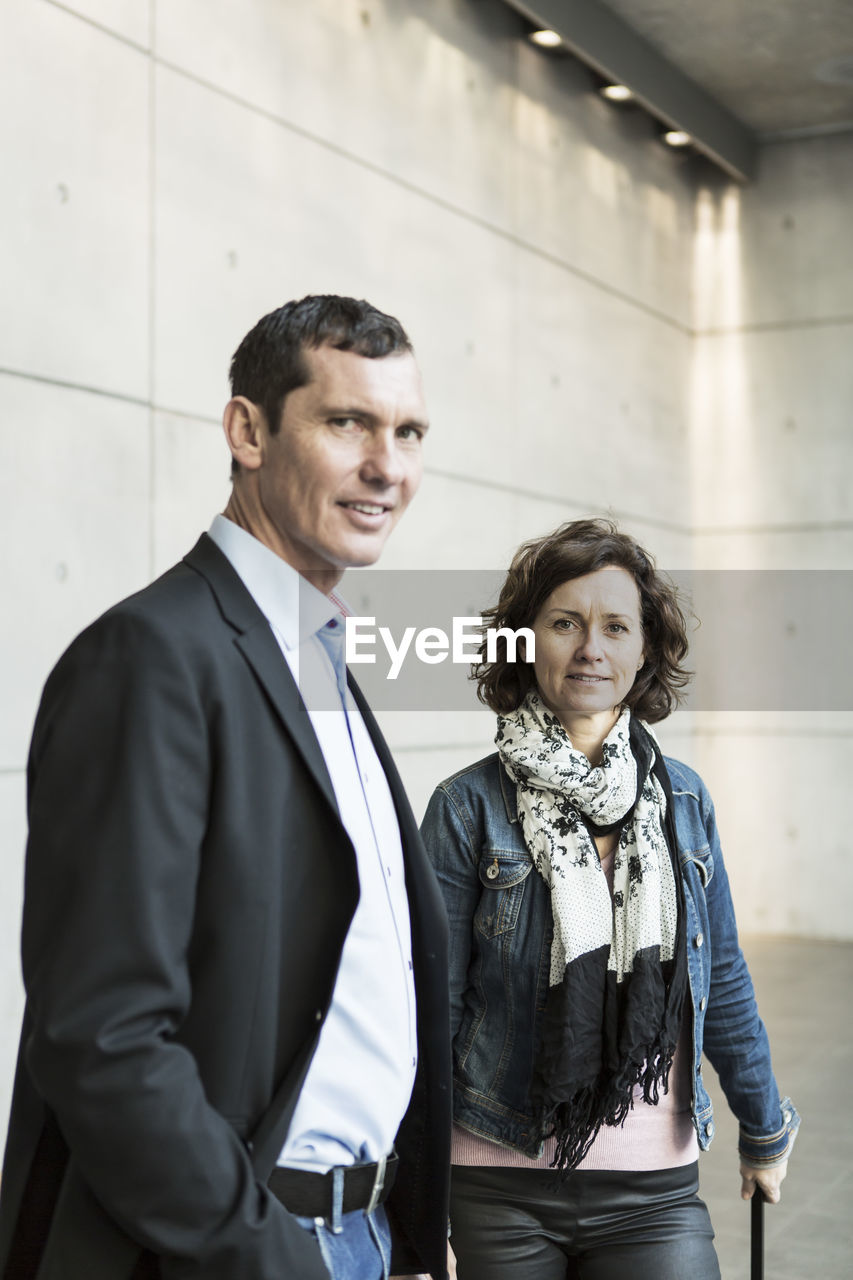 Portrait of confident business people standing at railroad station