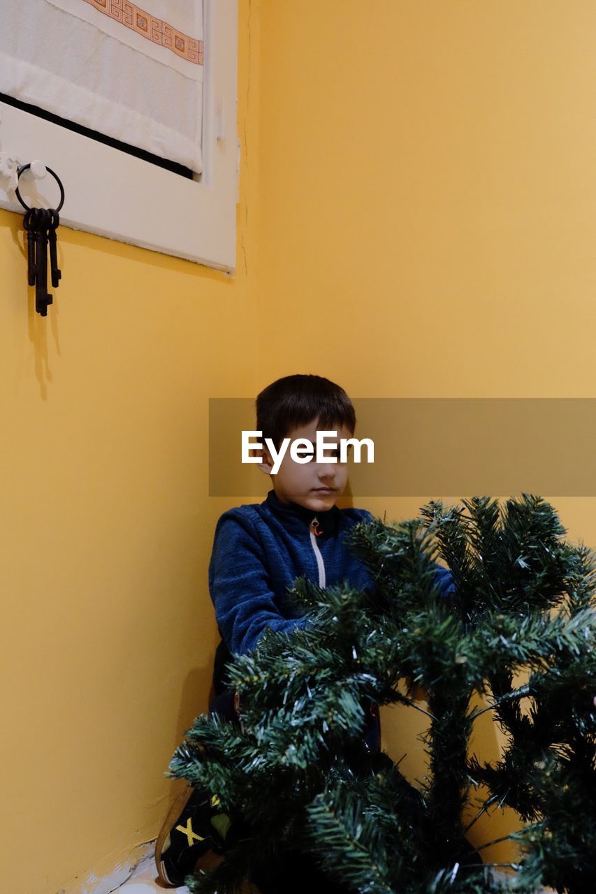 BOY LOOKING AT CHRISTMAS TREE IN RESTAURANT