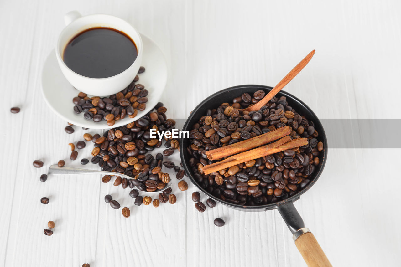 HIGH ANGLE VIEW OF COFFEE BEANS ON TABLE AGAINST WALL