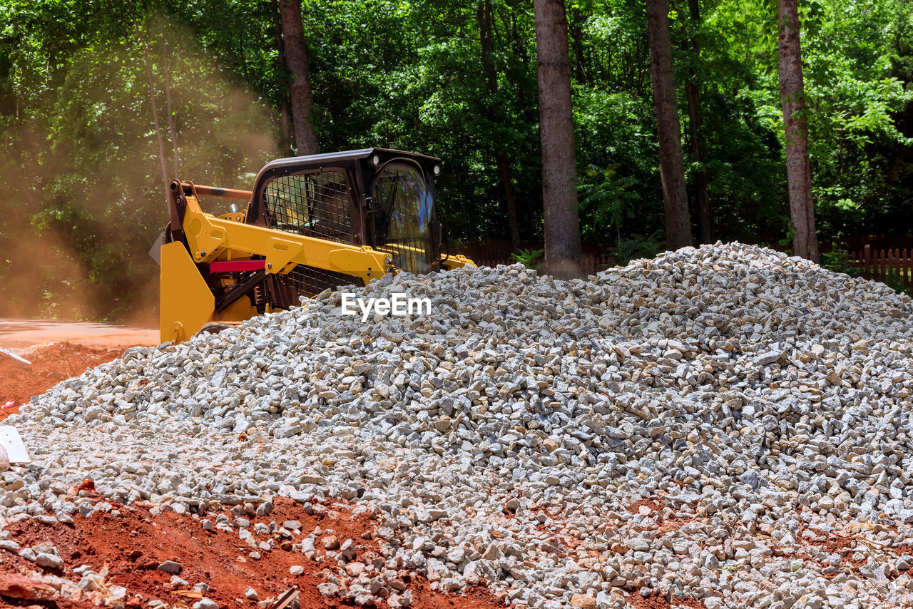 soil, construction machinery, tree, construction industry, machinery, construction site, plant, transportation, earth mover, nature, asphalt, industry, heap, bulldozer, day, no people, land, forest, mode of transportation, land vehicle, road construction, outdoors, vehicle