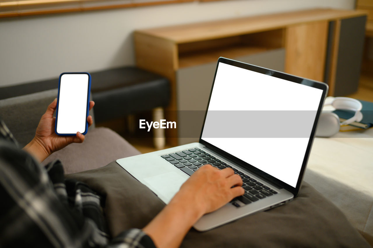 midsection of man using laptop at table