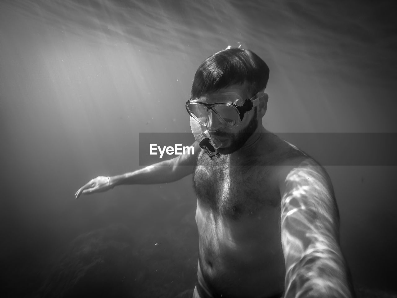 Shirtless man swimming in sea