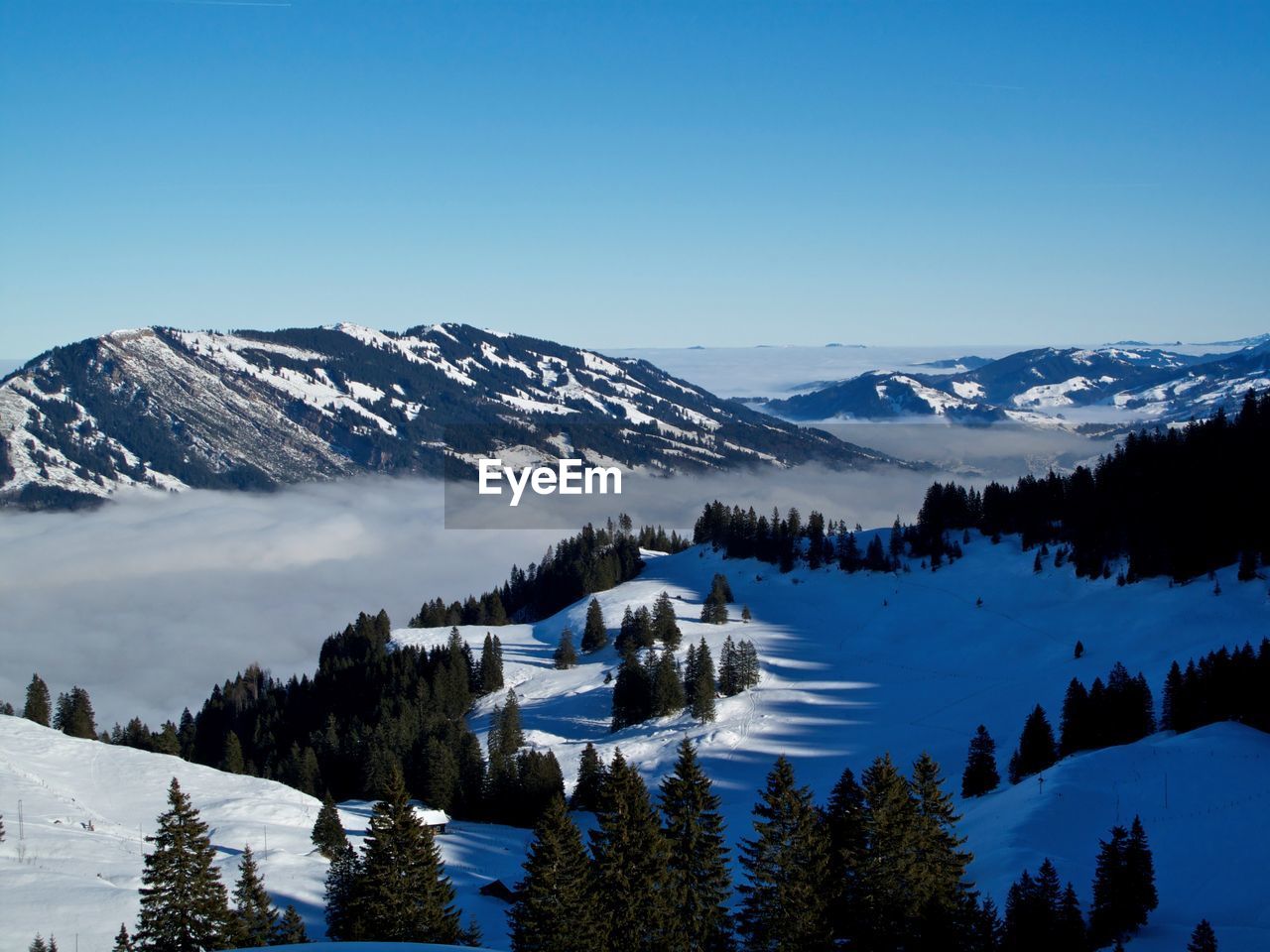 Scenic view of snowcapped mountains against clear blue sky