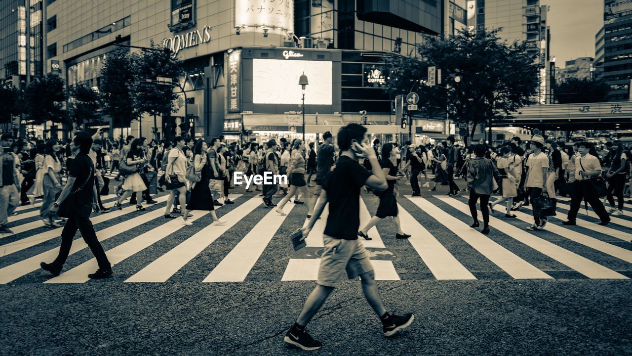 PEOPLE WALKING ON ROAD IN CITY