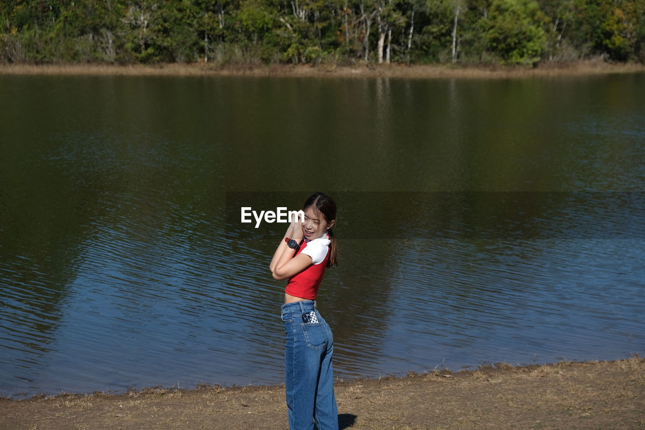 Rear view of girl standing by lake
