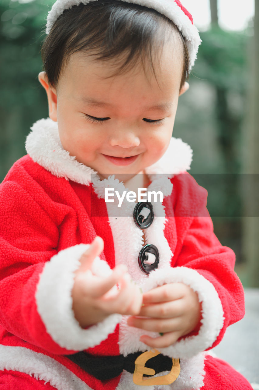 CLOSE-UP OF CUTE BOY HOLDING BABY GIRL IN SNOW