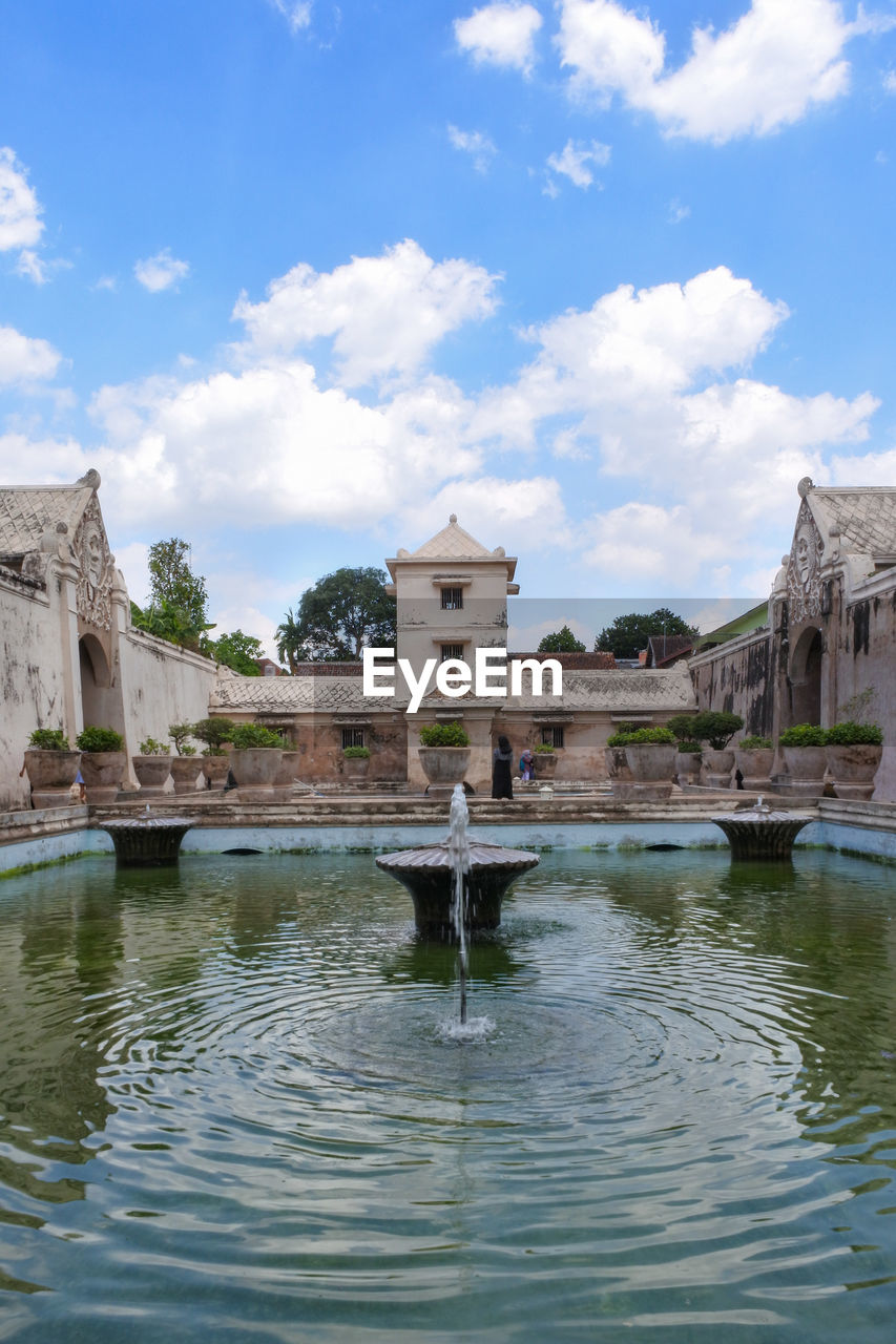 Fountain against buildings in city