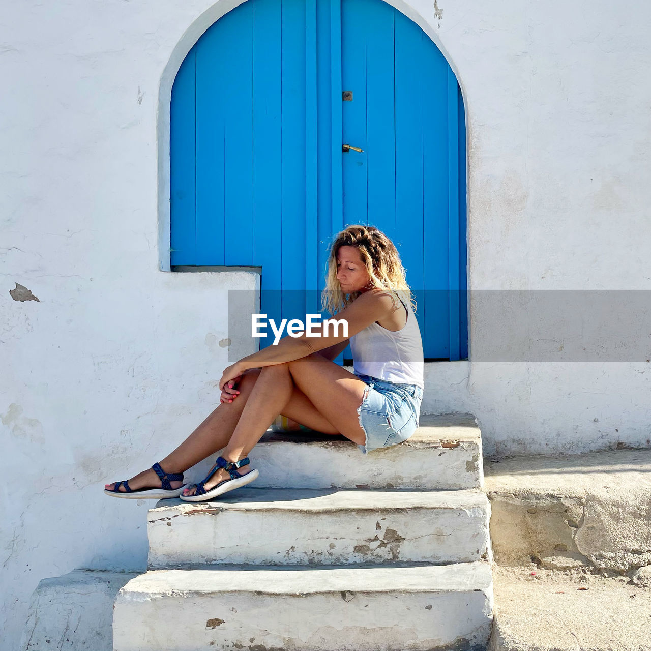 Full length of young woman standing against wall