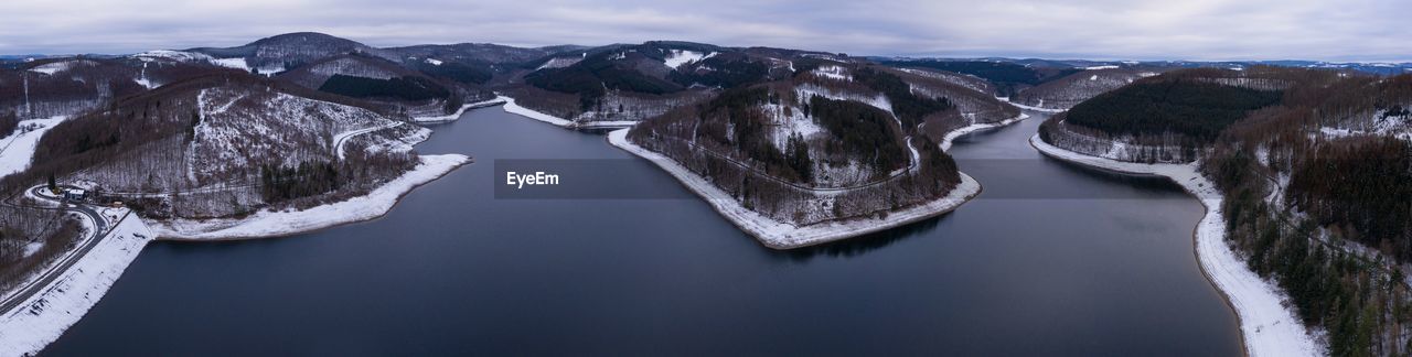 PANORAMIC VIEW OF LAKE AGAINST SNOWCAPPED MOUNTAINS