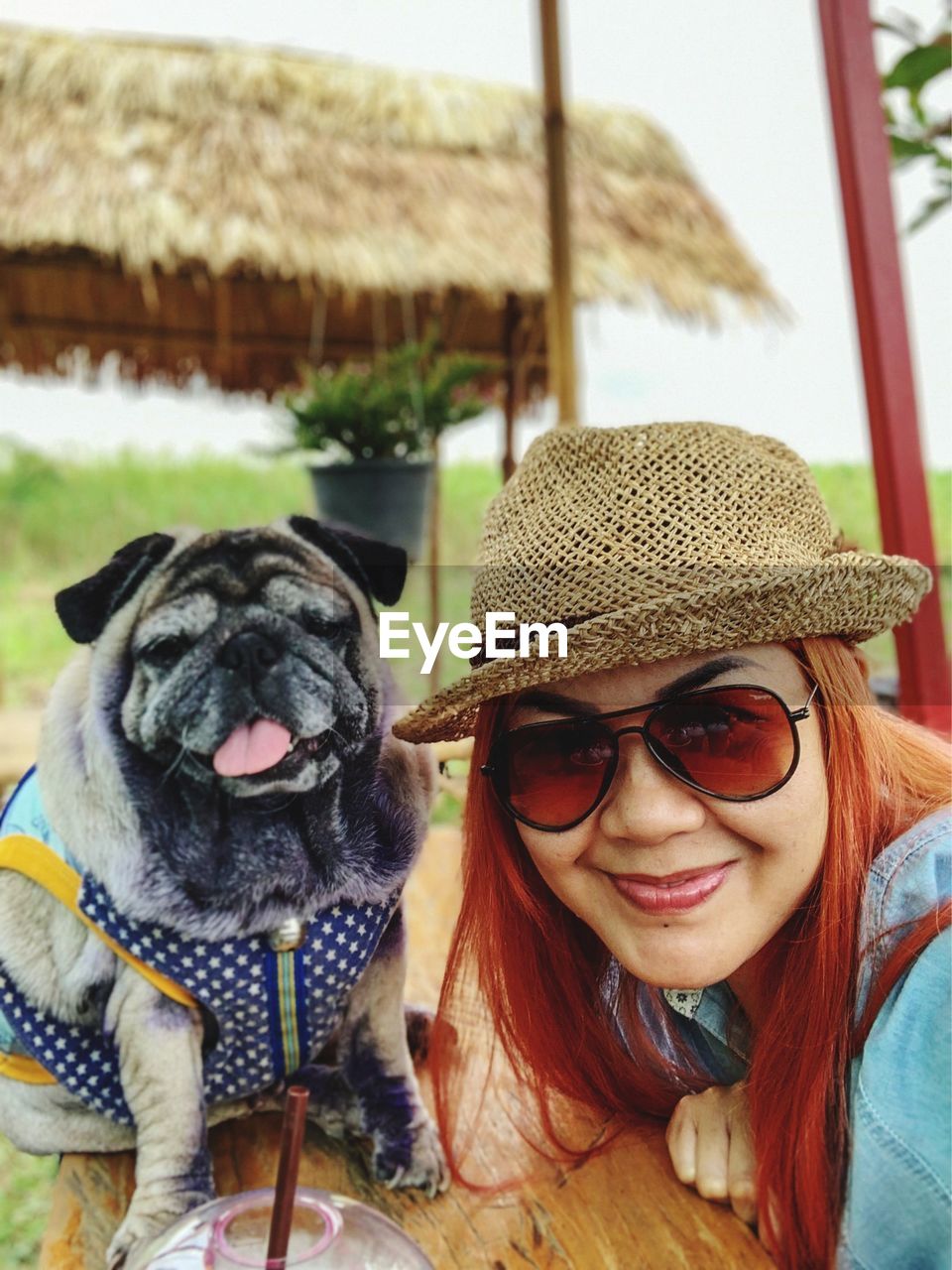 Portrait of woman in sunglasses with dog outdoors