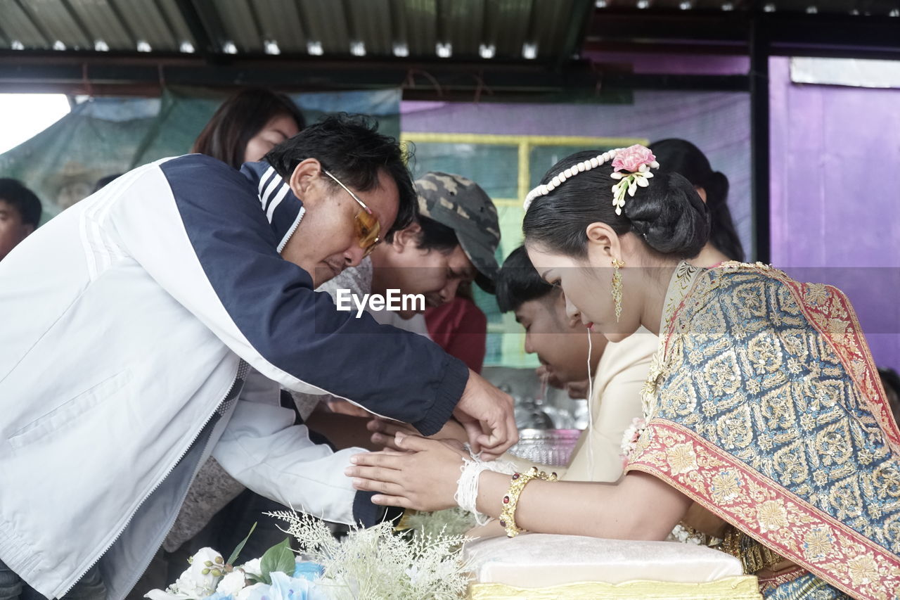 GROUP OF PEOPLE IN TRADITIONAL CLOTHING AT HOME