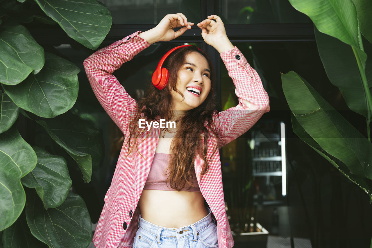 Portrait of smiling young woman standing in park