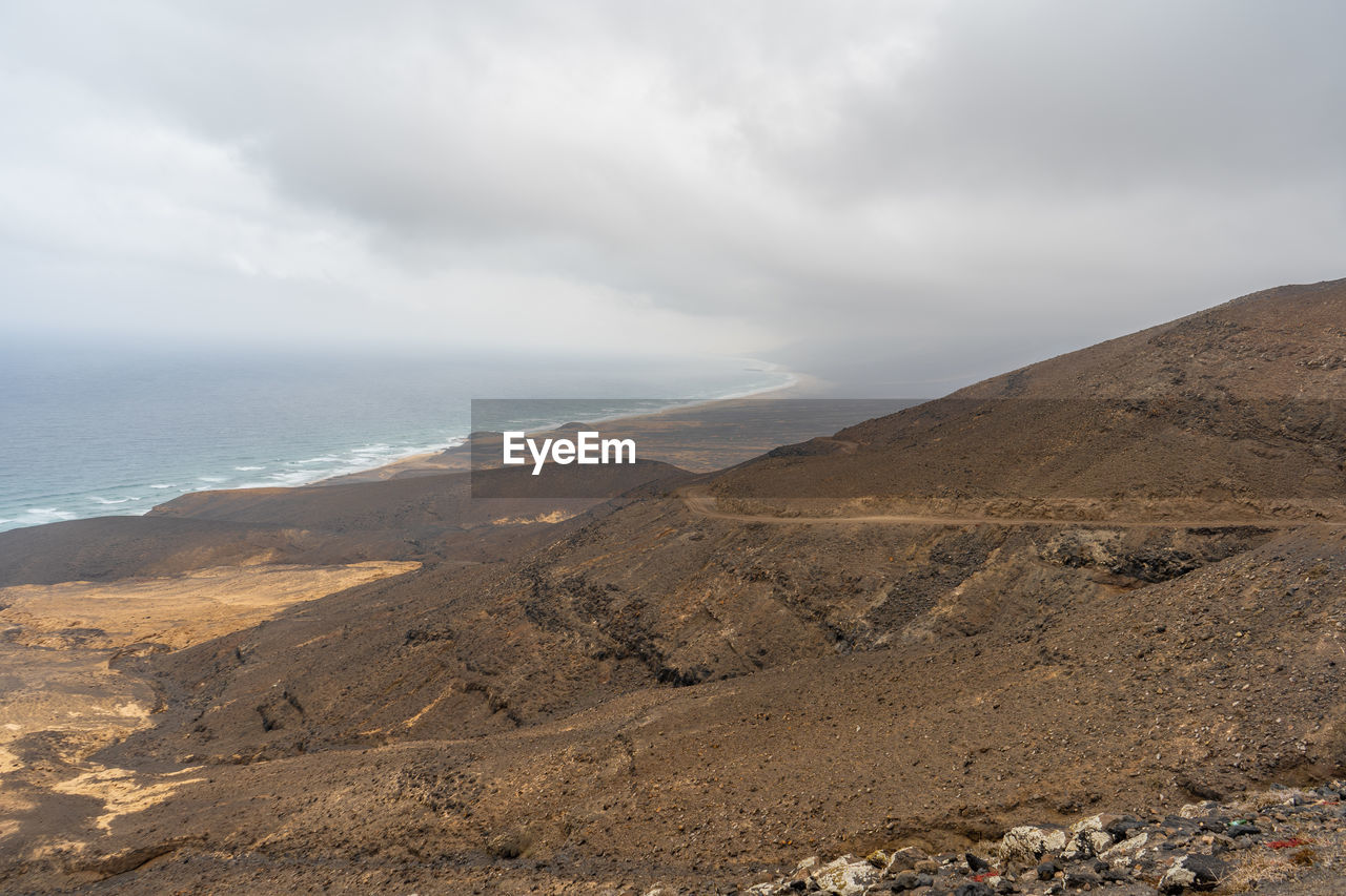 Scenic view of sea and mountains against sky