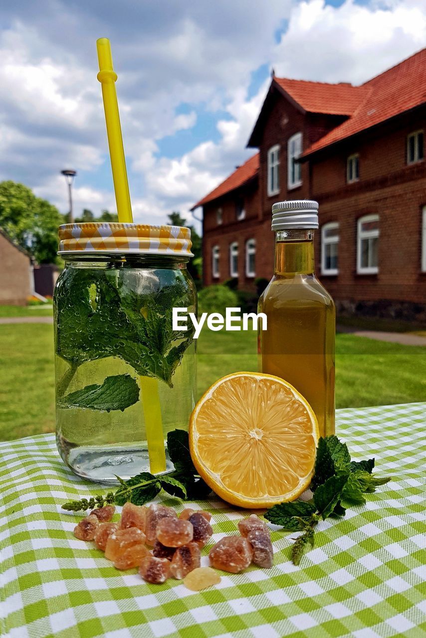 Close-up of fresh lemonade with herbs on table in back yard