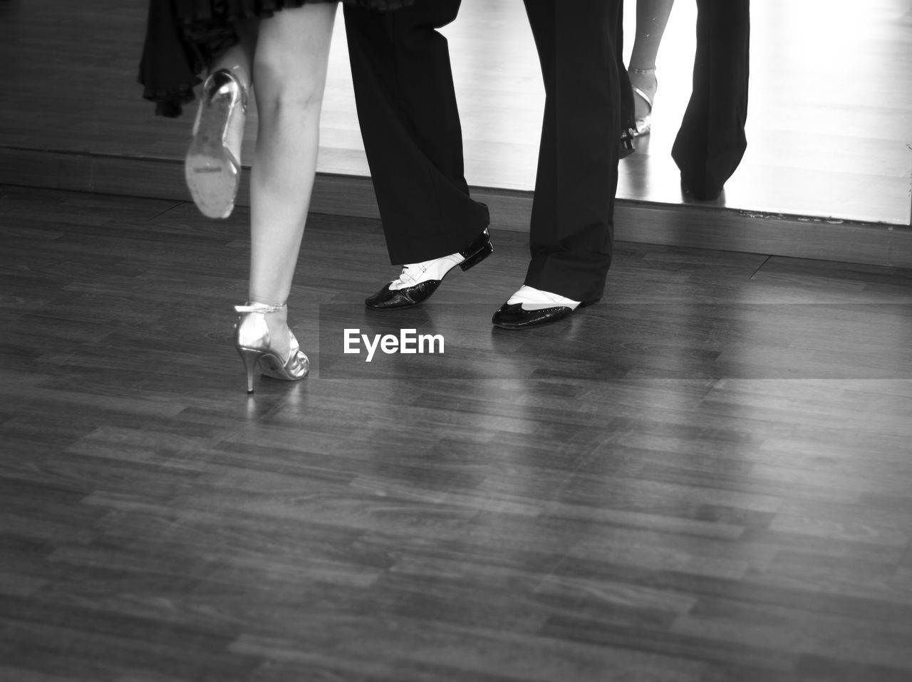 Low section of woman and man standing on hardwood floor