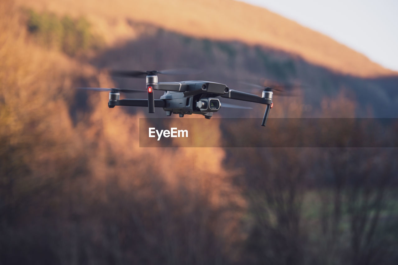 Low-angle view of a professional camera drone/quadrocopter at sunset